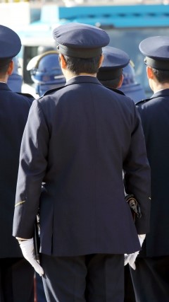 後ろ姿を見せる男性警察官